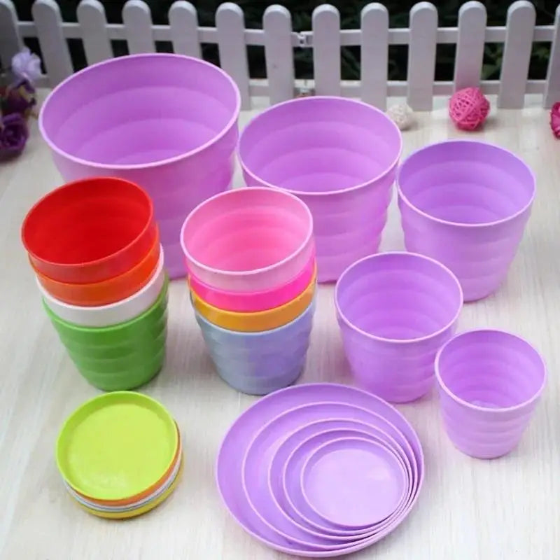 Assorted purple plastic flower pots, plus a few small green and red pots