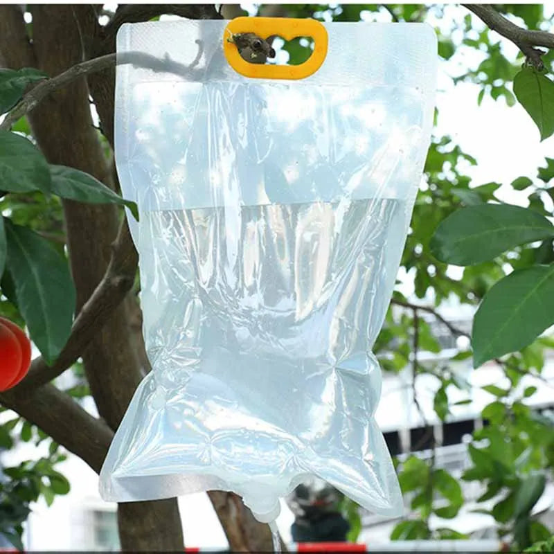 Clear automatic plant watering bag with yellow carry handle and drip outlet