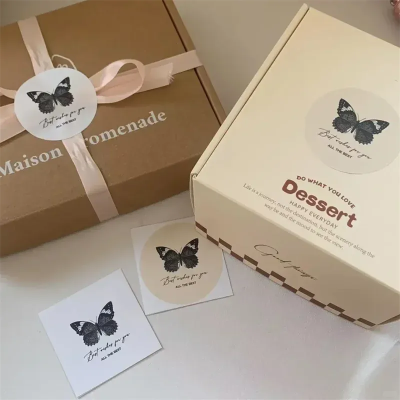 Round white custom logo stickers with black butterfly and handwritten-style text