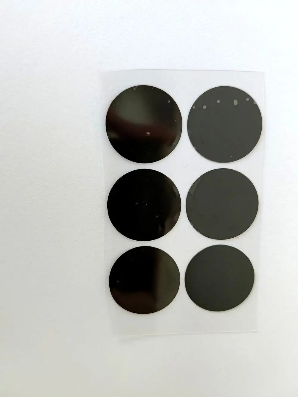 Six 28mm diameter black replacement film stickers for Vmax HIFU cartridges on a clear adhesive sheet.