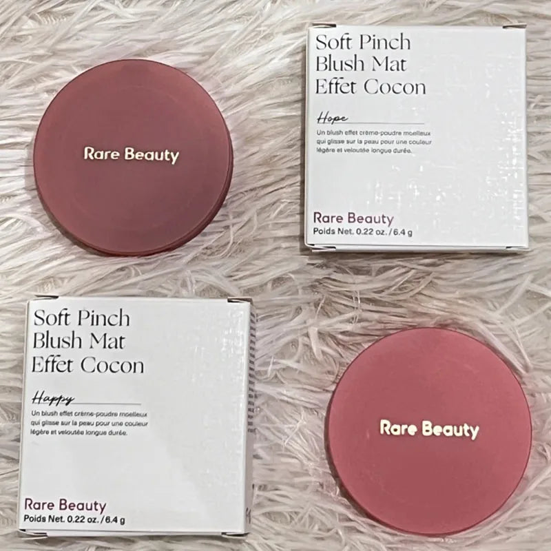 Rare Beauty Soft Pinch Luminous Powder Blush in shades Hope and Happy with sleek matte compacts and product boxes.