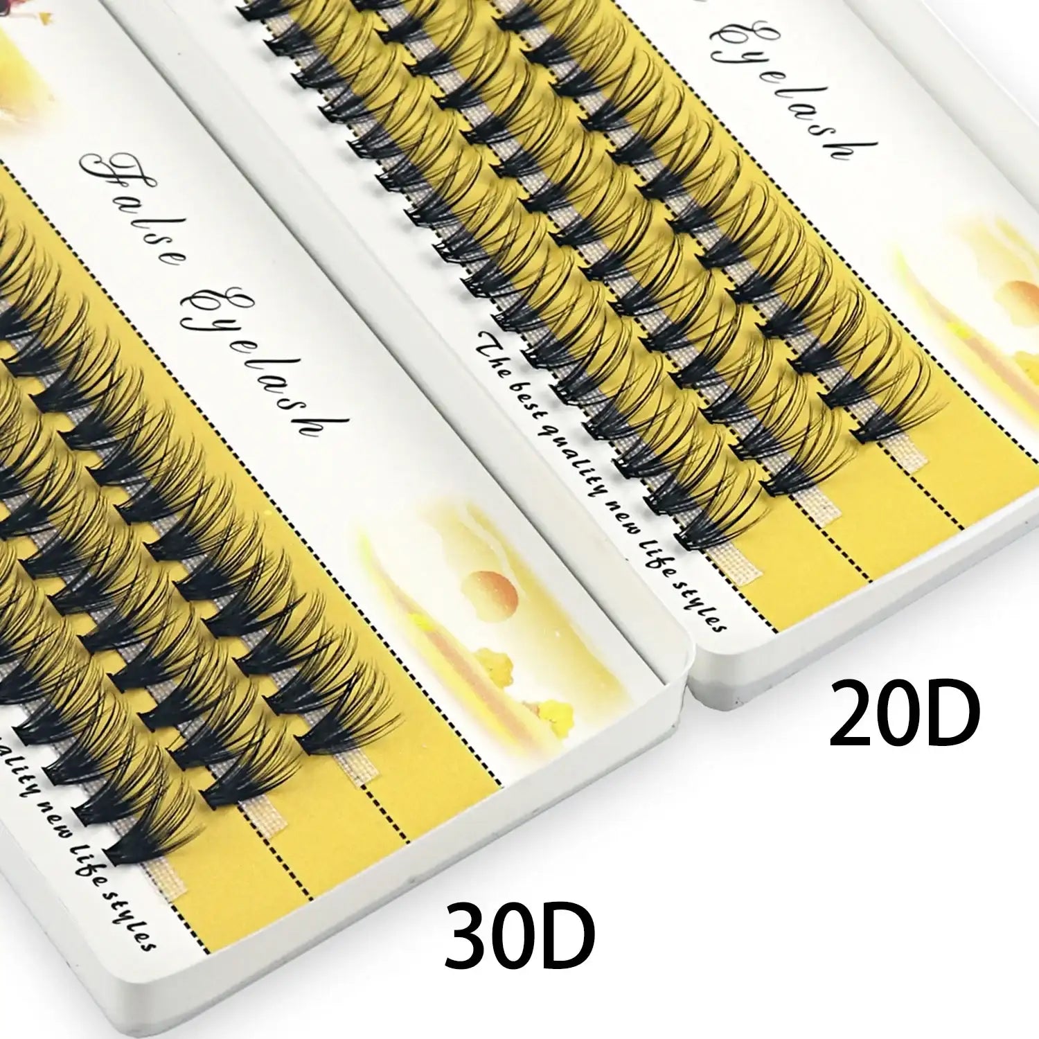 A box of 20D and 30D individual cluster black mink eyelashes arranged on a yellow tray for makeup extensions.