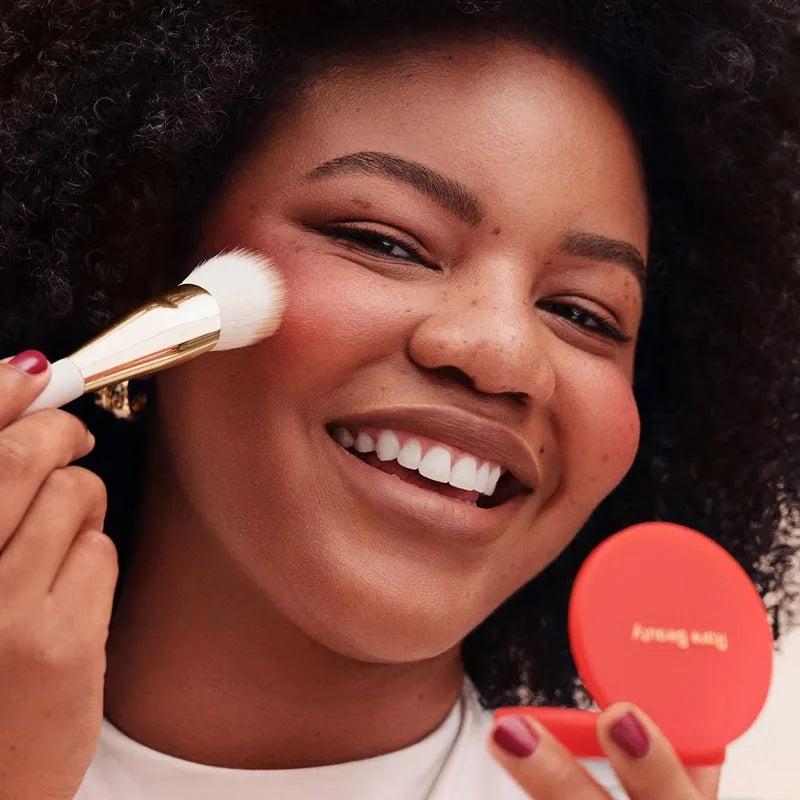 Rare Beauty Soft Pinch Luminous Powder Blush being applied with a brush for a smooth, vibrant pink glow.