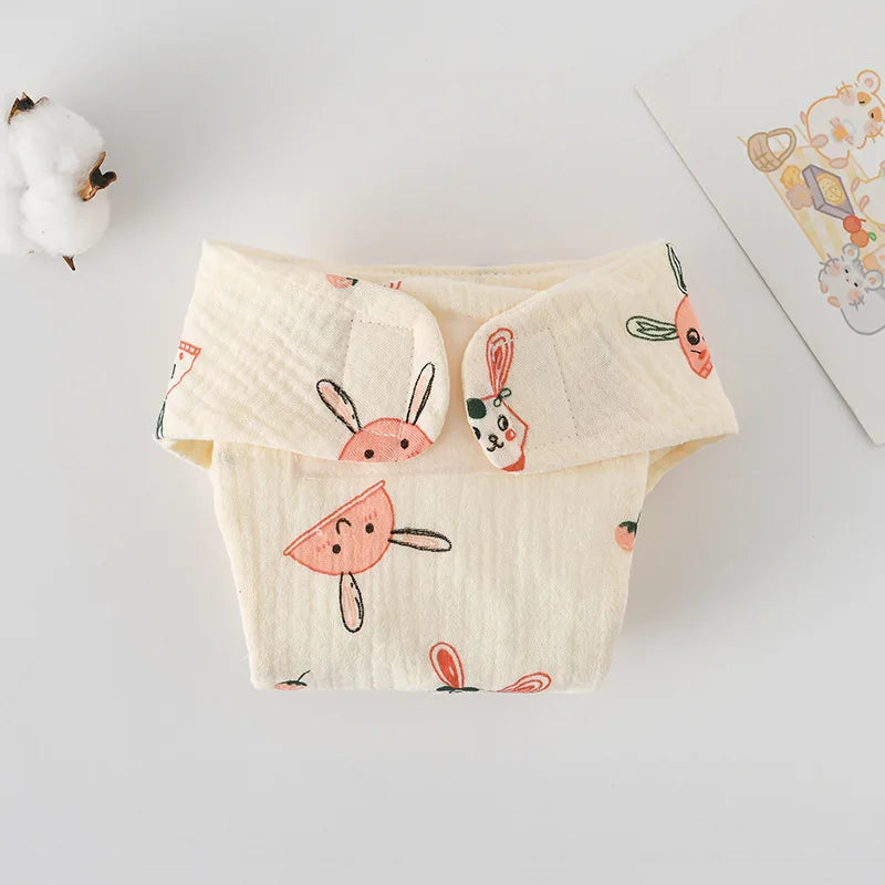 Cream-colored baby cloth diaper cover with cute bunny print. Soft, breathable muslin baby care essential.
