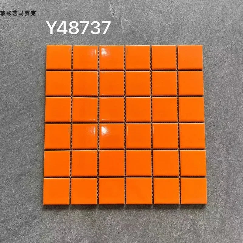 Ceramic mosaic tile sheet with glossy bright orange square tiles on grid backing