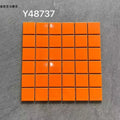 Ceramic mosaic tile sheet with glossy bright orange square tiles on grid backing