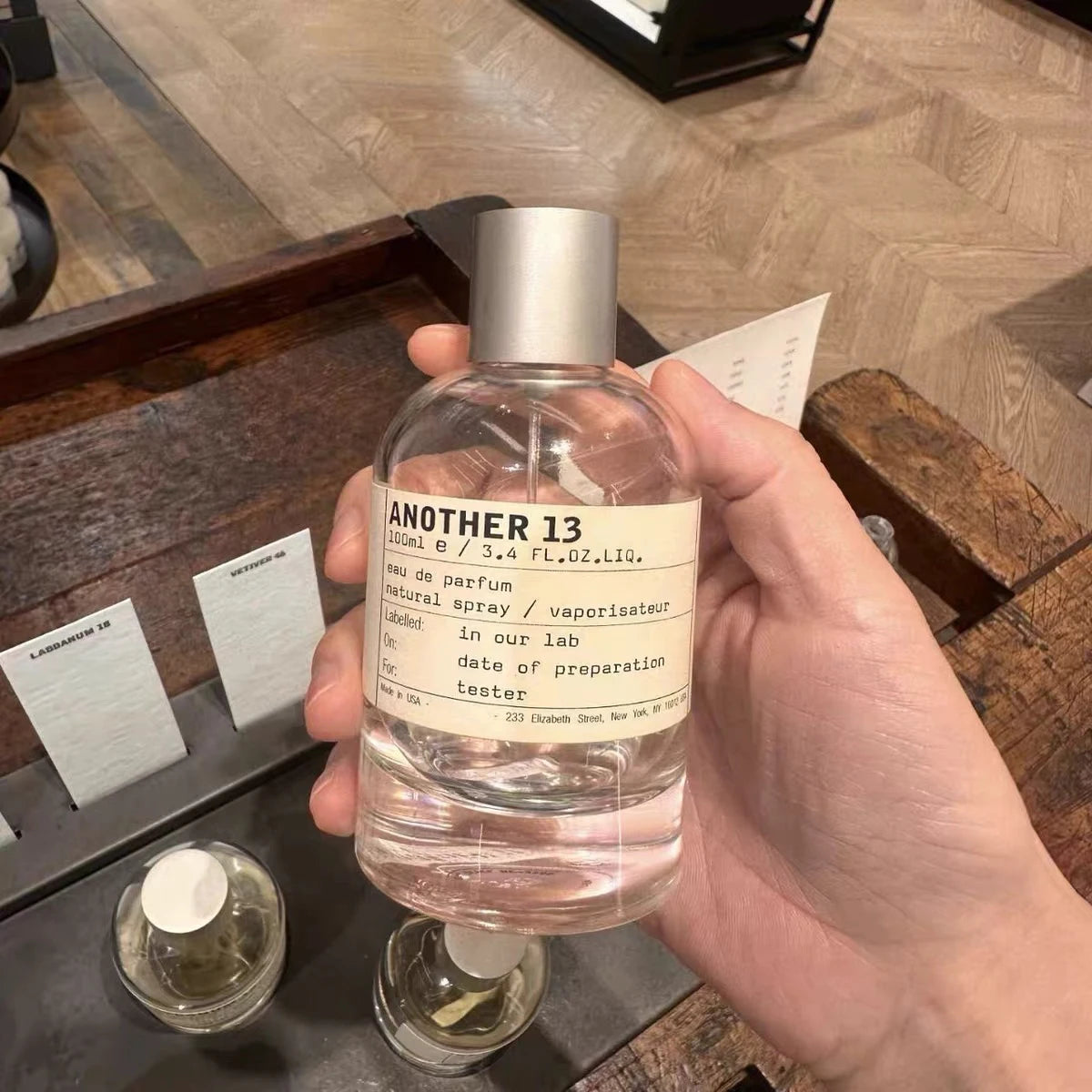 Le Labo Another 13 unisex EDP, 100ml clear round bottle perfume spray. Iconic cult fragrance with minimalist label.