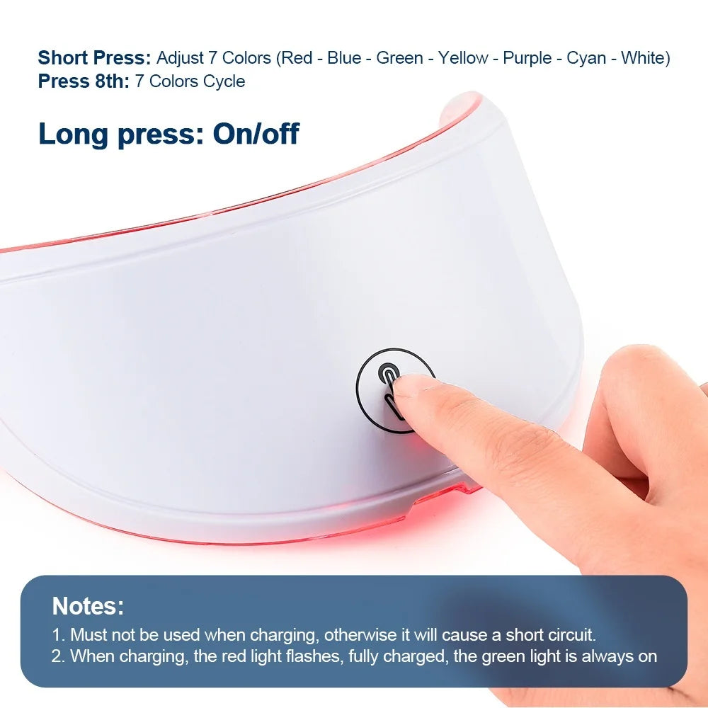 White, curved LED face mask control panel being pressed by a finger, showing text instructions for 7 light colors.