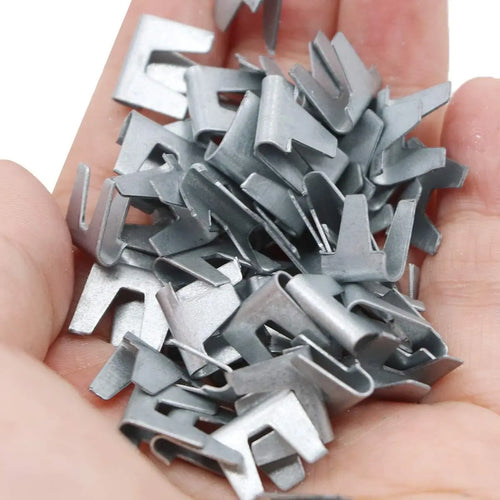 Silver metal pet cage binding clips, mixed pieces in a hand