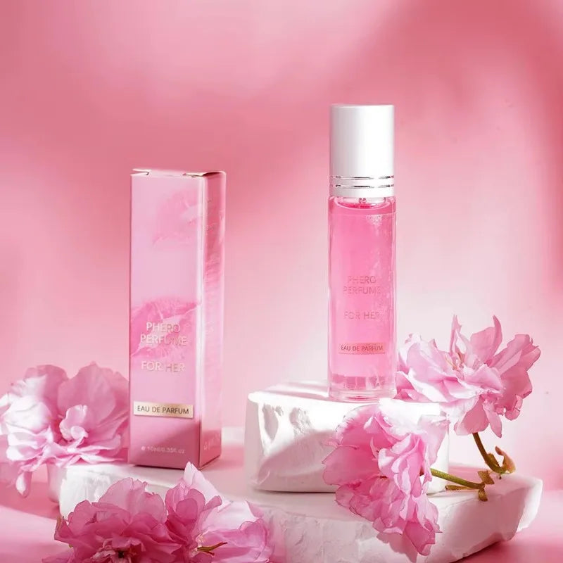 Phero Perfume for Her in a 10ml pink glass roll-on bottle and matching carton, surrounded by pink flowers.