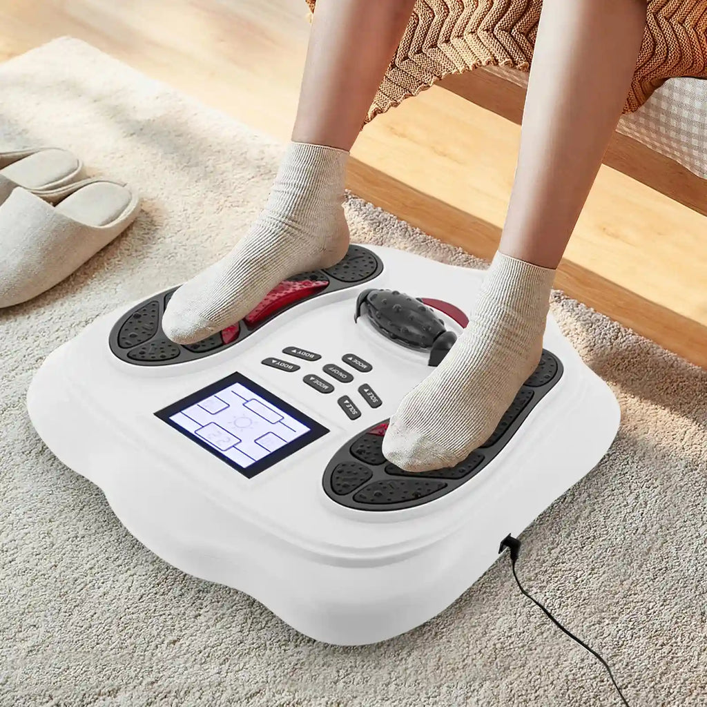 White electric foot massager with digital display for leg blood circulation, used at home with socked feet.