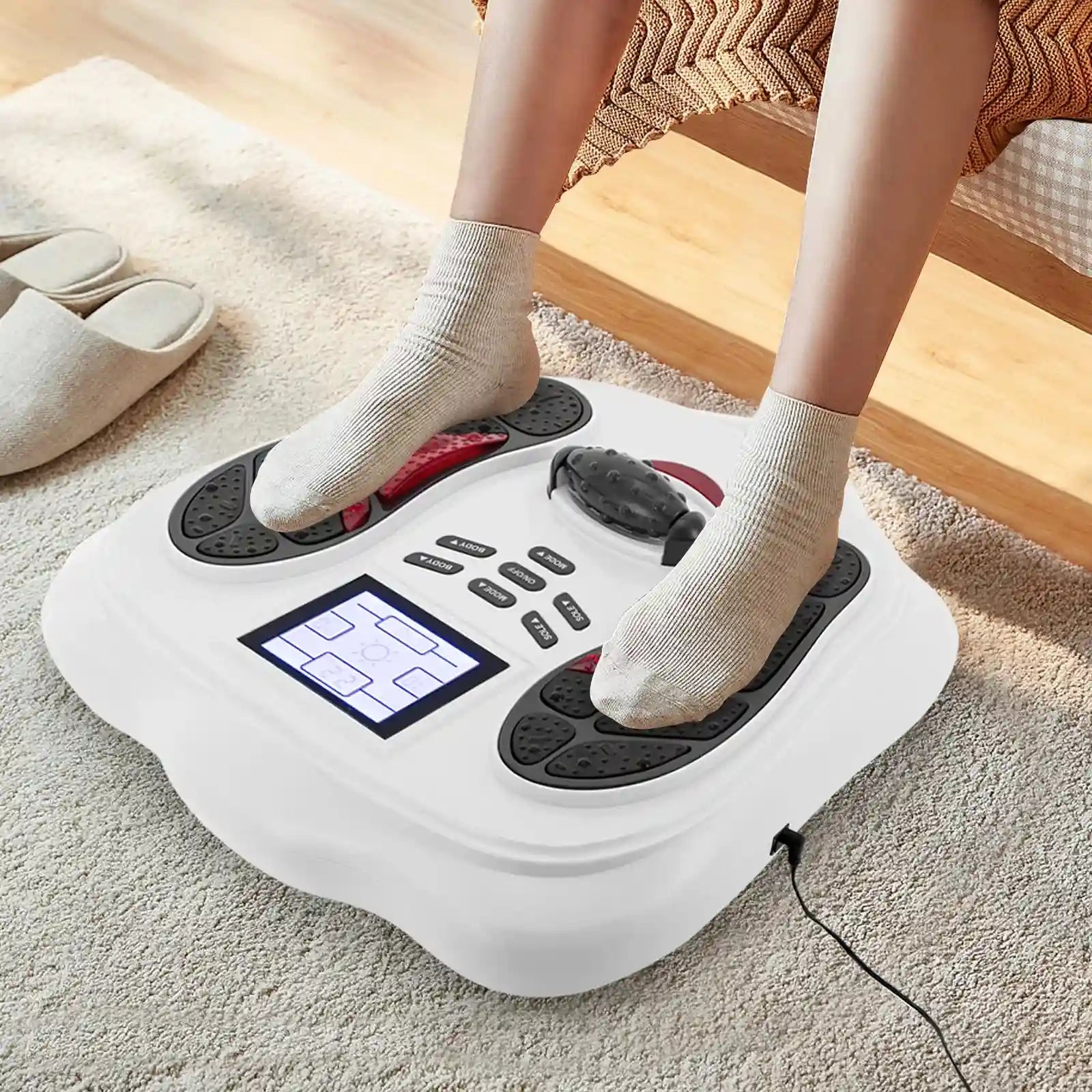 White electric foot massager with digital display for leg blood circulation, used at home with socked feet.