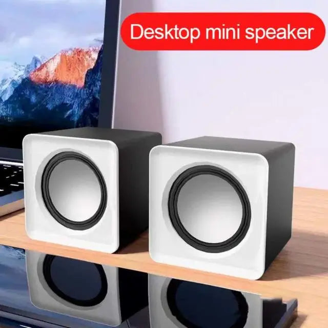 White mini desktop speaker pair with black rings and top USB ports