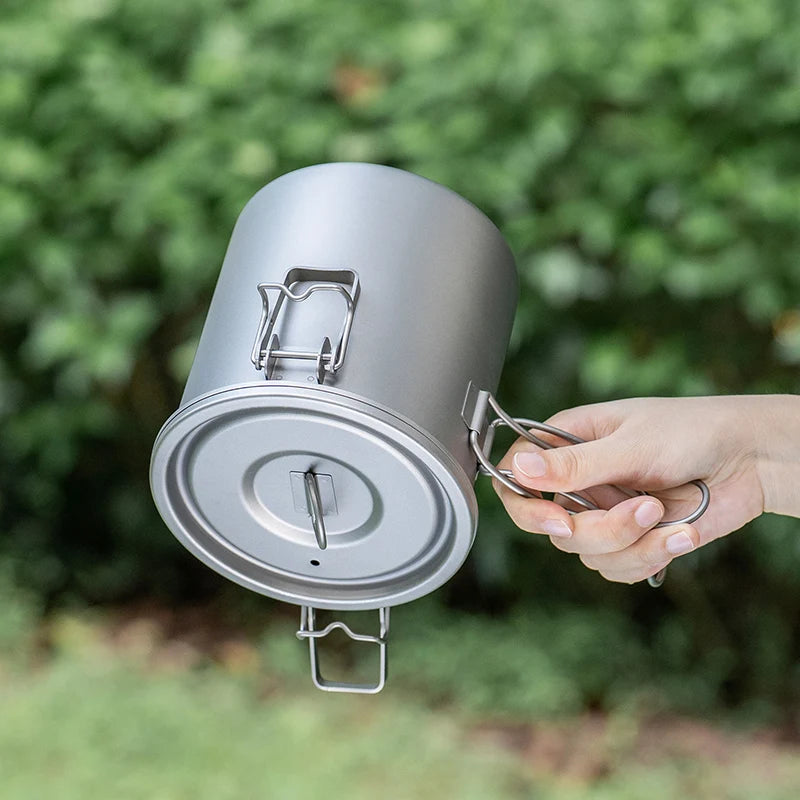 Ultralight titanium pot with lid lifted, spoon tool and bail handle visible