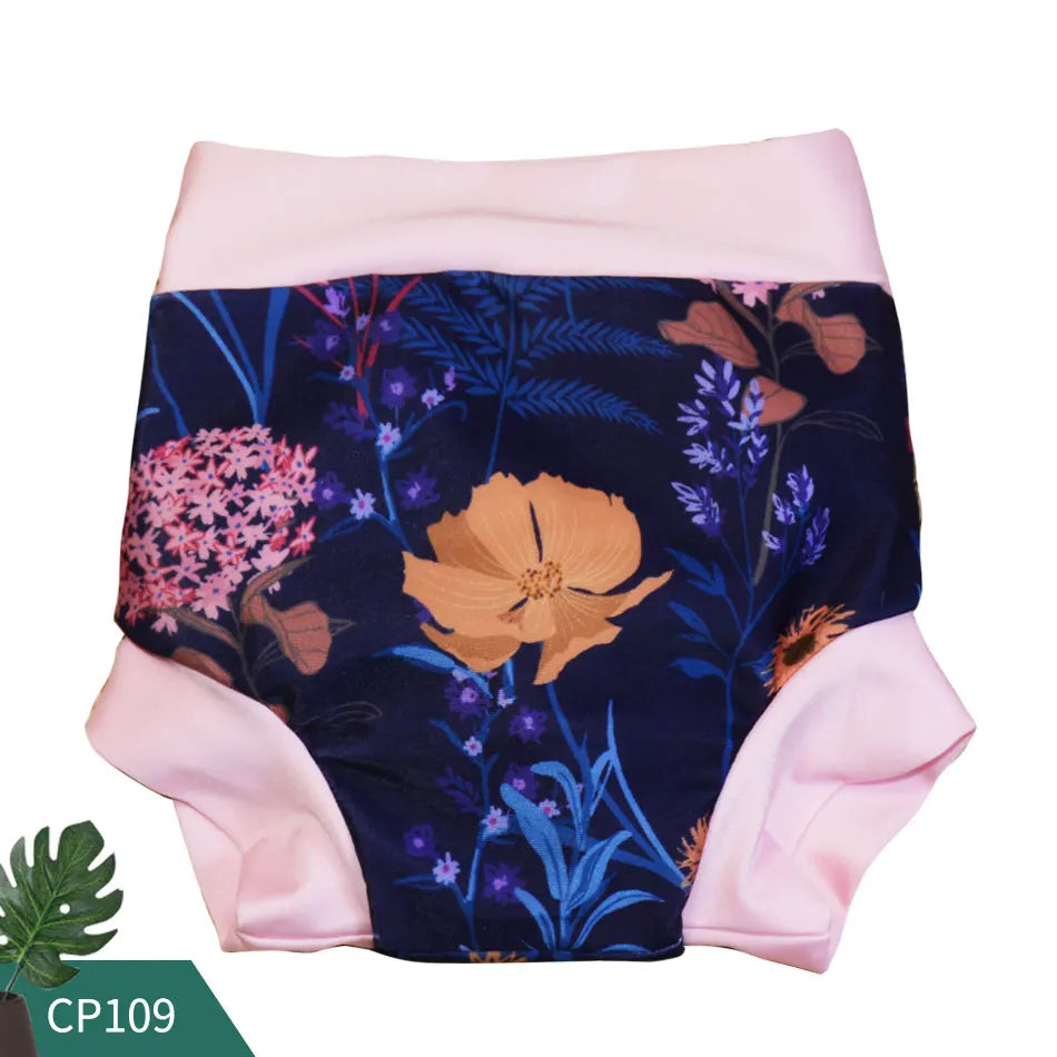 Baby swim diaper in dark blue floral botanical print with soft pink trim, model CP109, reusable baby care essential.