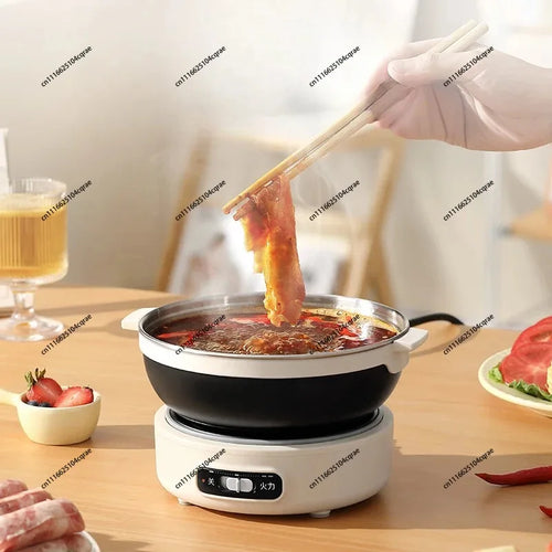Electric hot pot cooker with black bowl holding broth, lid open while food is added