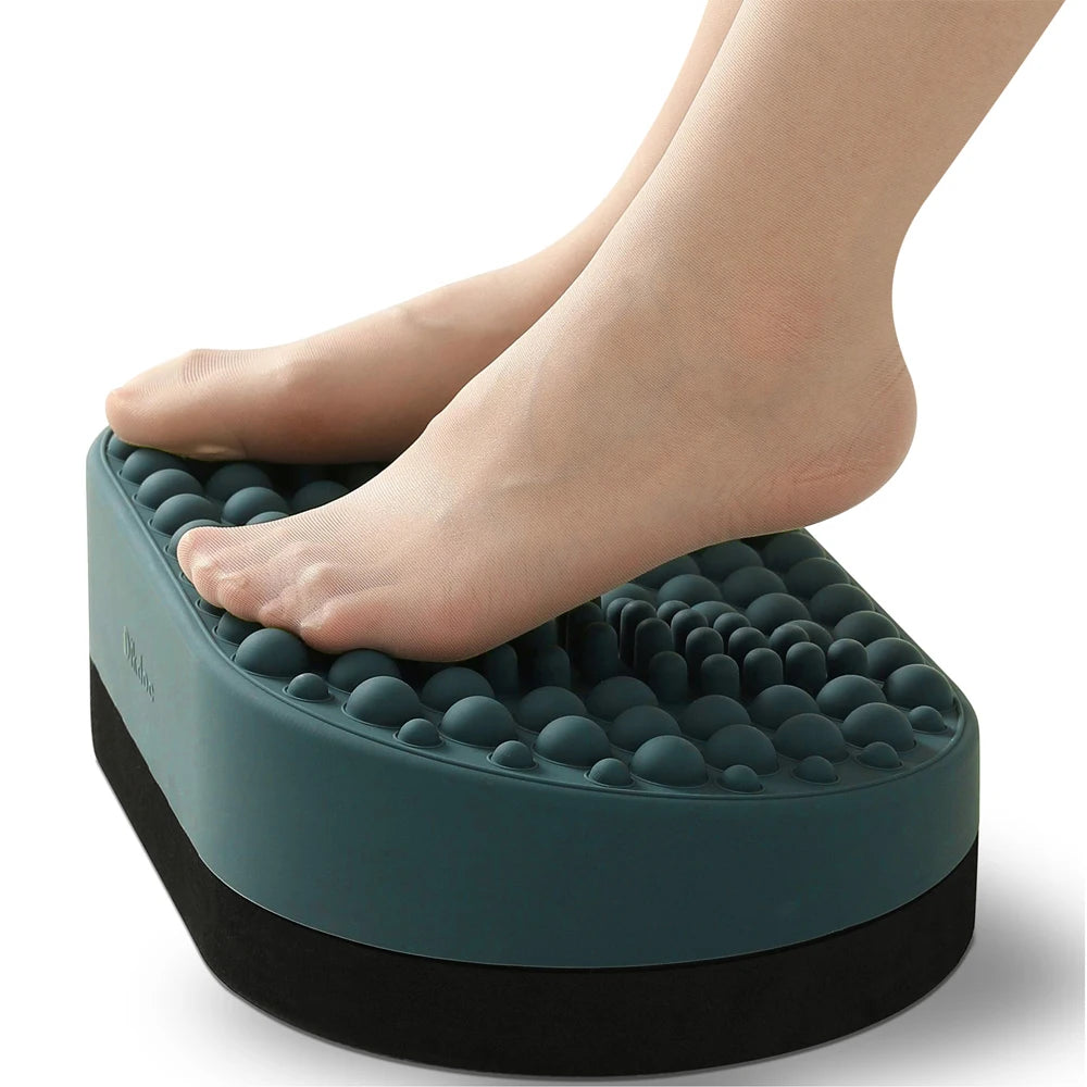 Dark green silicone foot rest for under desk with textured massage nodes for relief under feet on a white background.