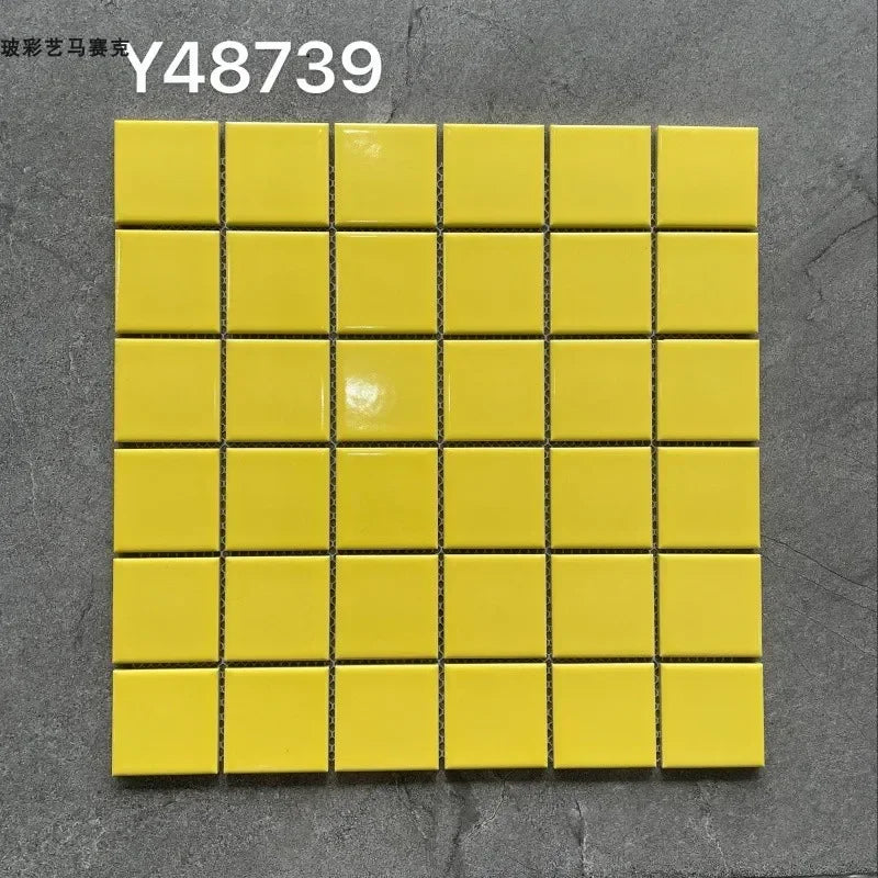 Ceramic mosaic tile sheet with small square yellow tiles on grid backing