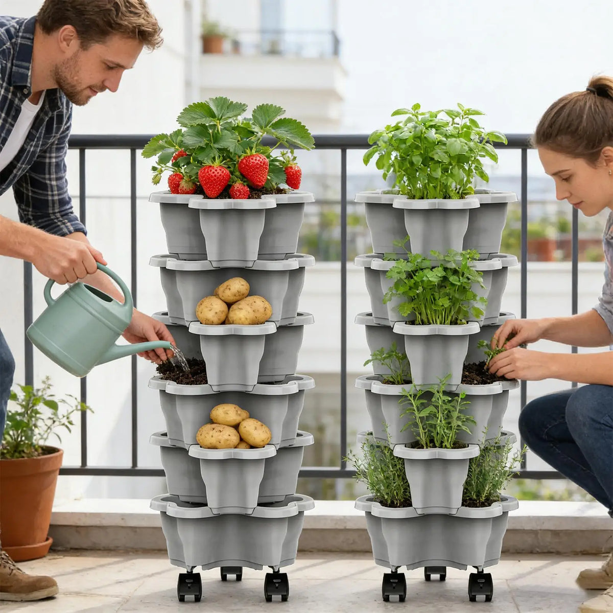 Gray plastic vertical planter tower with four tiers and wheels being watered with a green watering can