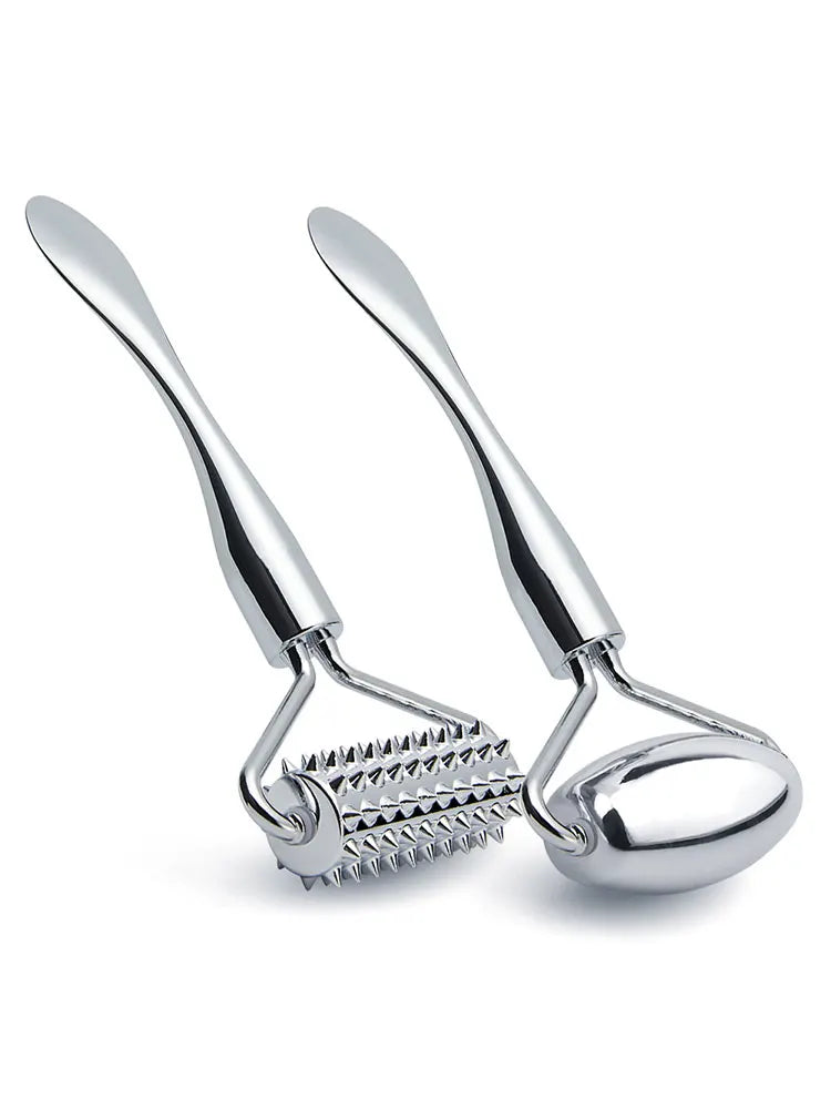 Two silver zinc alloy facial massagers: one with a spiky textured roller and one with a smooth, oval-shaped roller.