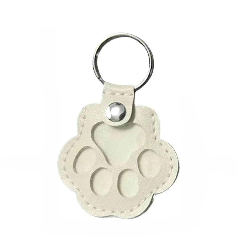 Beige leather cat paw keychain storage bag for carrying pet hair mementos as an elegant bag pendant.