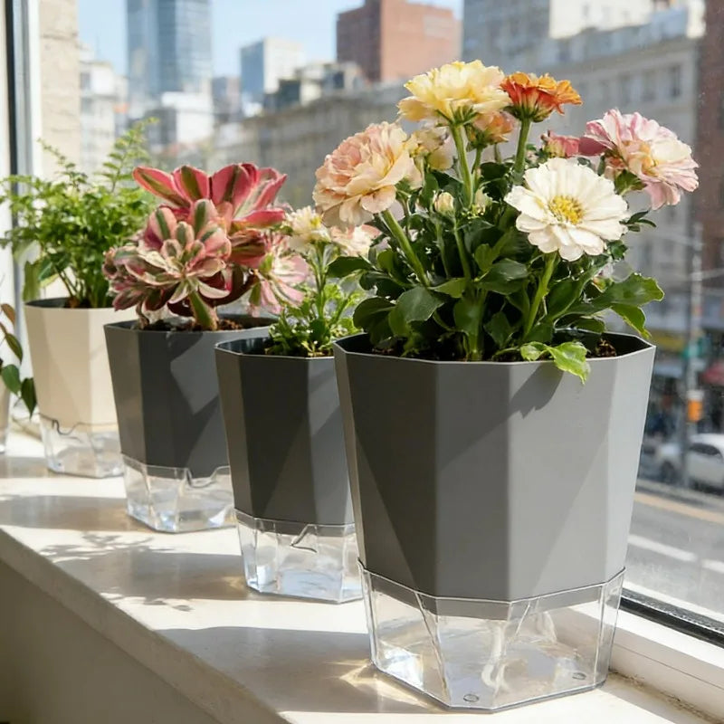 Set of three self-watering flower pots with injection holes, gray planters on window ledge