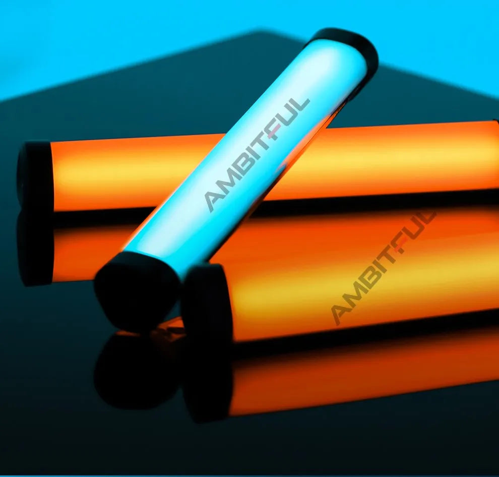 Two cylindrical LED light sticks with black end caps, one glowing cool blue and one warm orange, for photography