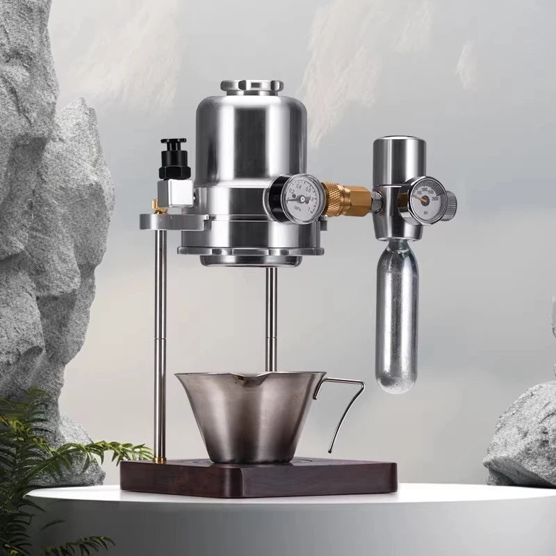 Manual stainless steel espresso maker with pressure gauges and cup on a wooden base for craft coffee brewing.