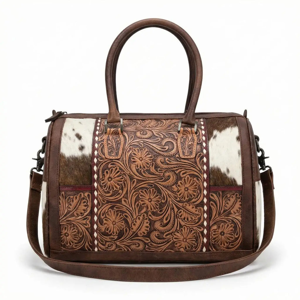 Brown genuine leather mini duffel with floral tooling, cowhide panels, top handles, and shoulder strap. Trunk style.