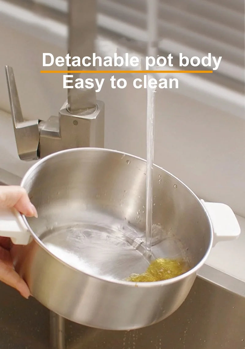 Stainless steel electric cooking pot with detachable body and pouring stream into inner bowl.