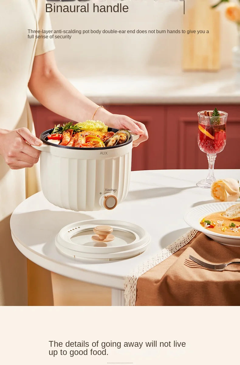 White mini electric rice cooker with lid and side handle on tabletop, compact hot pot.