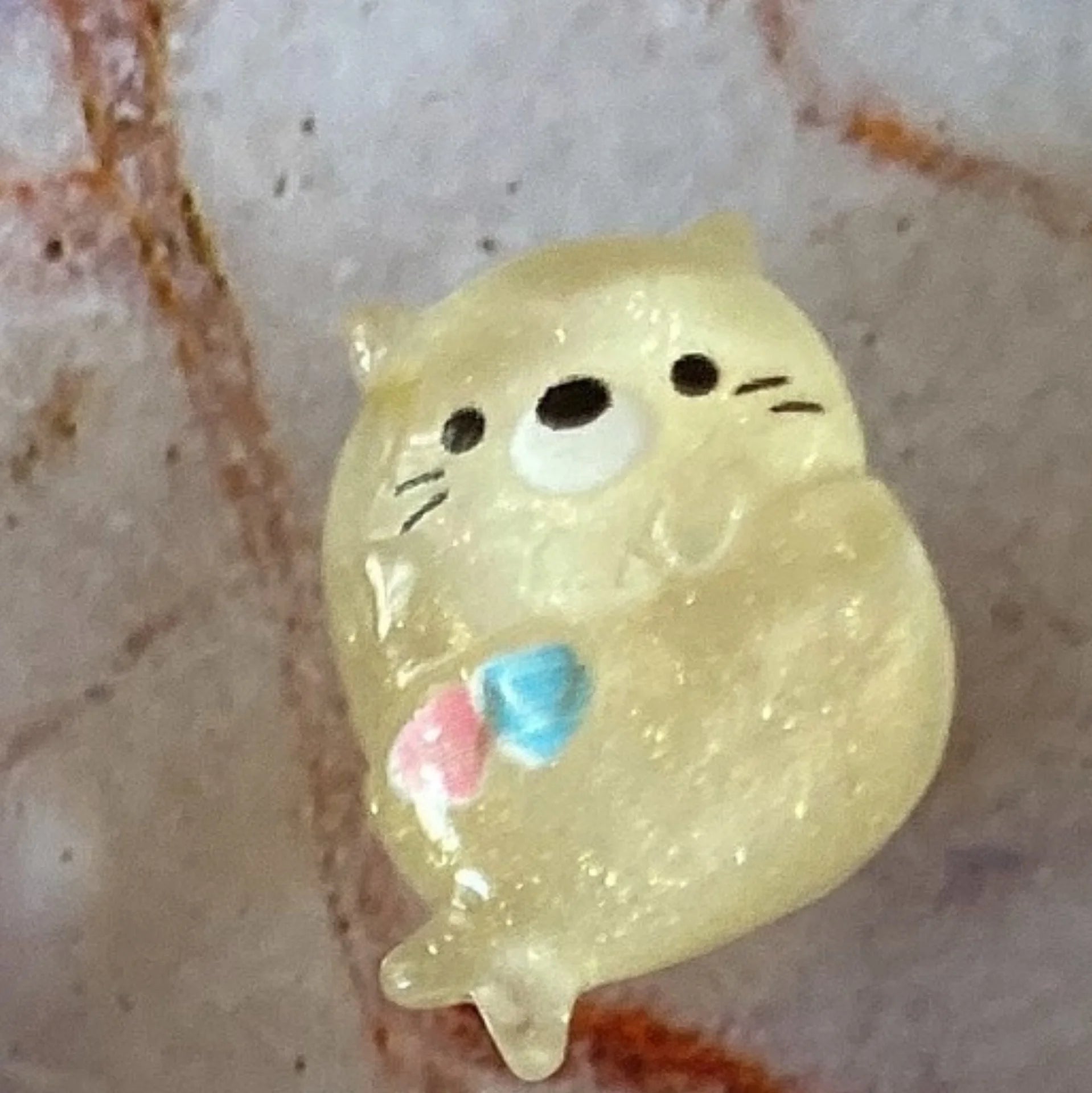 Cute yellow glitter sea otter dust plug for Tamagotchi Uni. Protect your device port with this charming silicone charm.