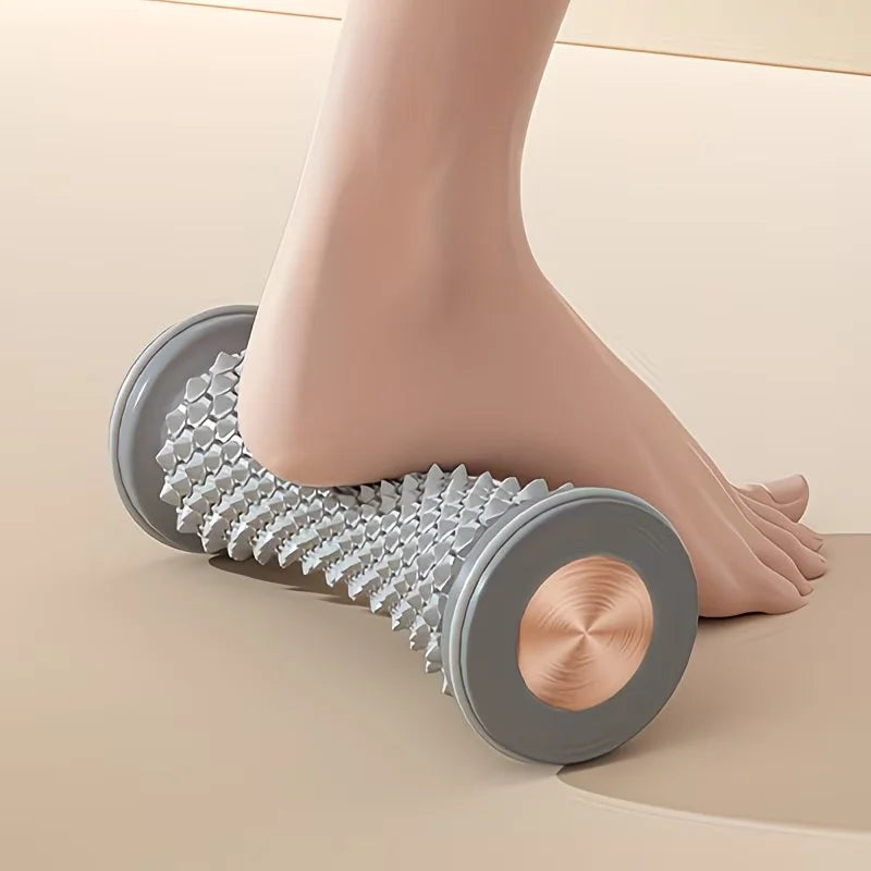 Grey spiky foot massager roller for plantar fasciitis relief and muscle relaxation during home yoga fitness.