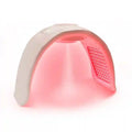 Arched white LED light therapy mask with internal red light panels for facial skin treatment.