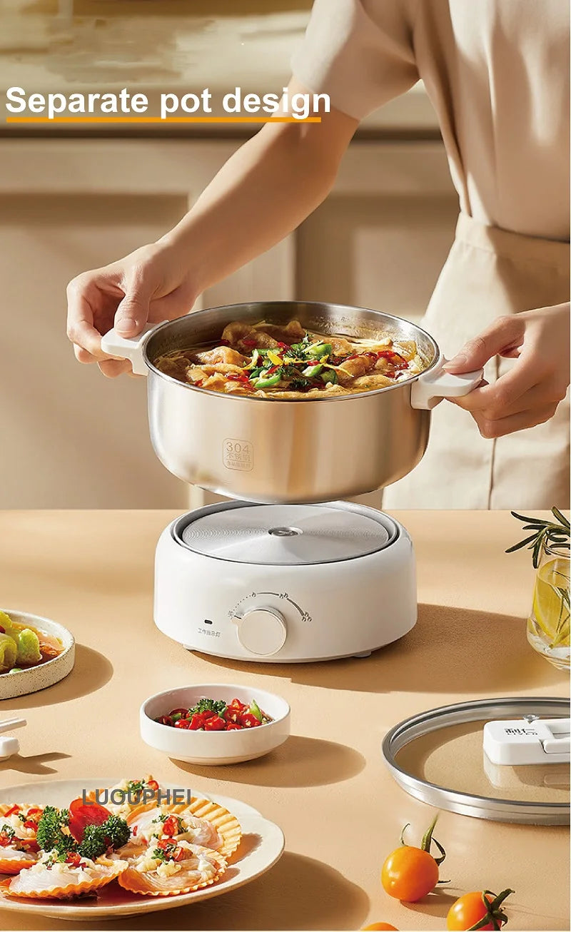 Electric split hot pot with stainless cookware and glass lid on a white heating base