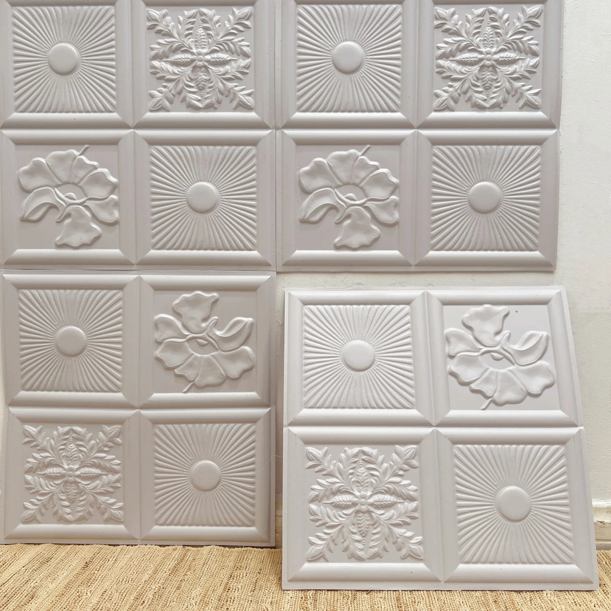 White embossed peel-and-stick backsplash tiles with floral and medallion relief pattern