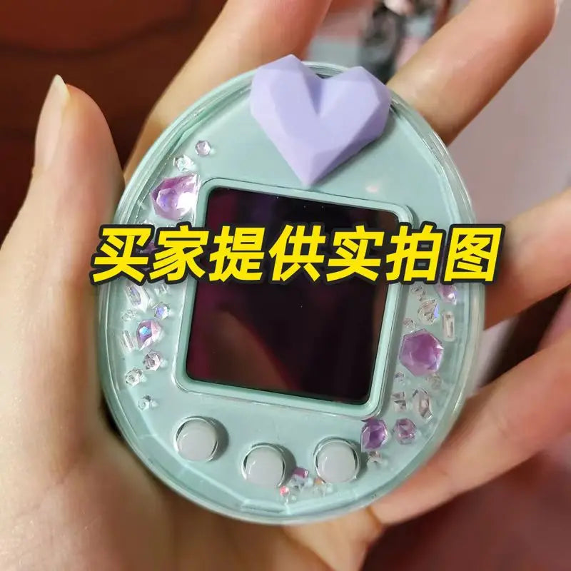 Tamagotchi Uni mint hard shell case with purple heart plug and crystal charms for stylish electronic pet protection.
