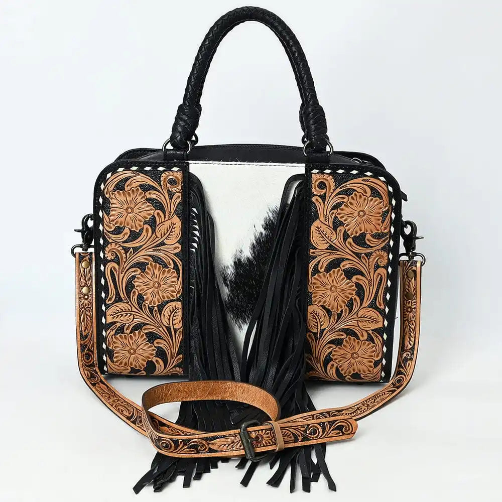Handmade genuine leather weekender bag with floral tooling, cowhide inlay, black fringe, and detachable shoulder strap.