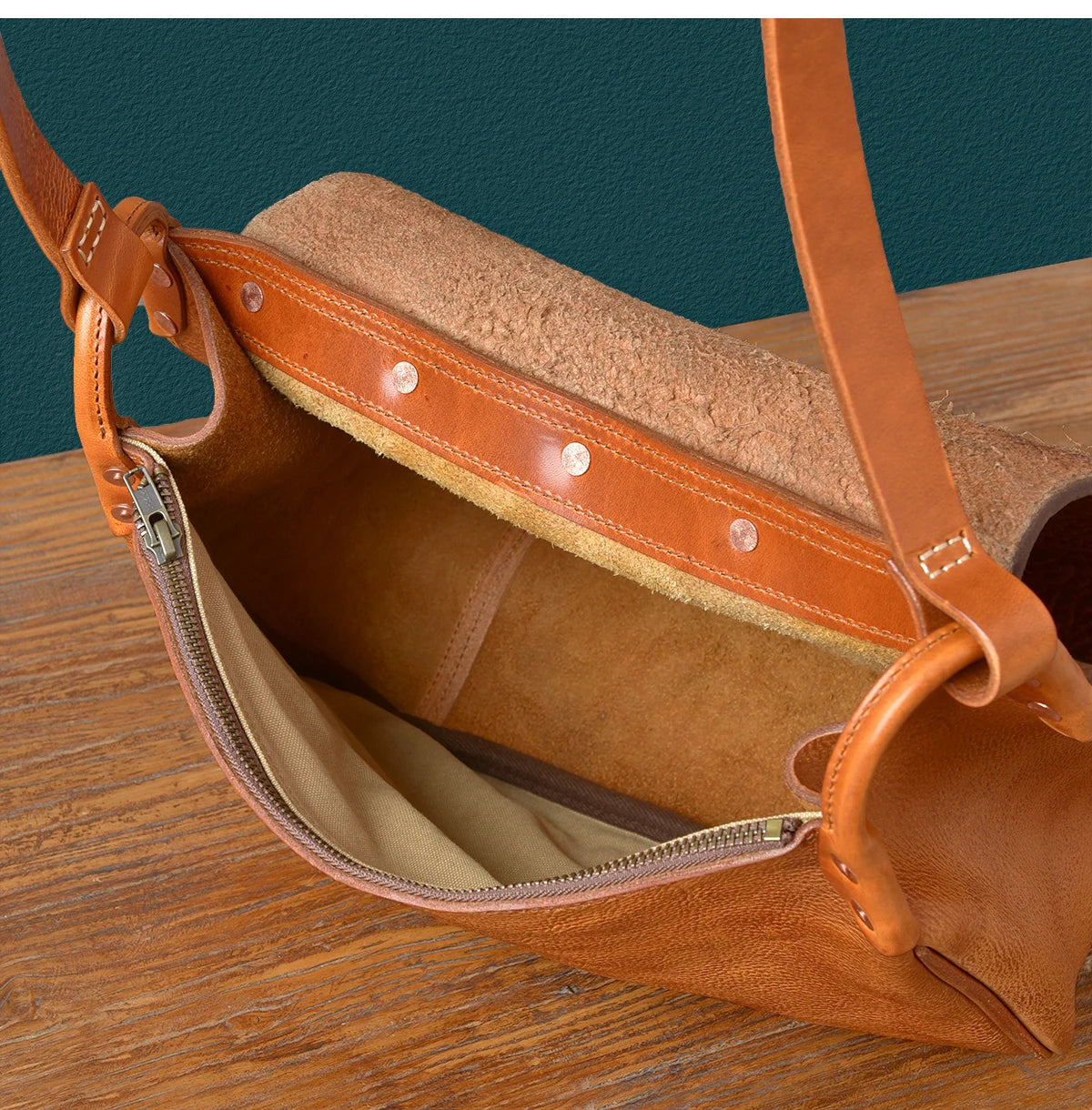 Vintage handmade tan cowhide leather messenger bag with rivet details, zipper closure, and sturdy shoulder strap.