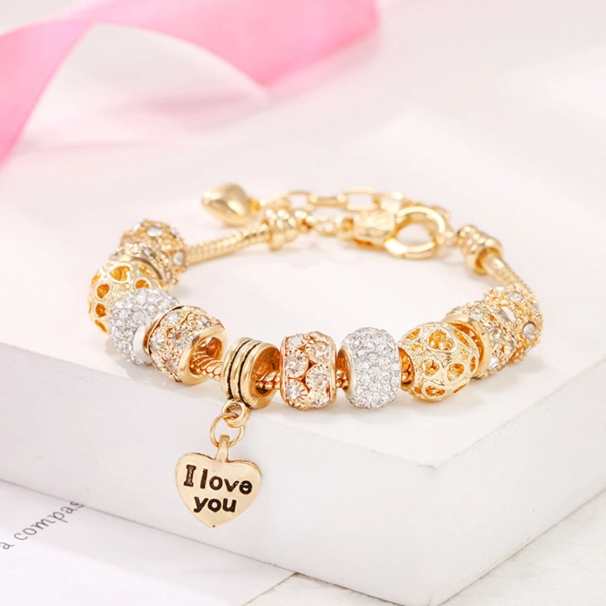 Tidesmit gold-tone charm bracelet featuring crystal-encrusted beads and a dangling heart pendant inscribed I love you.