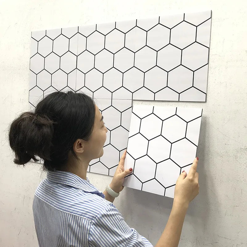 Peel-and-stick backsplash tiles with black-outlined white hexagon pattern
