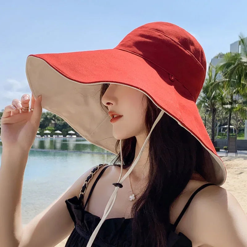 Tidesmit wide-brim sun hat with red top and beige underside, adjustable chin strap, soft fabric, worn on beach.