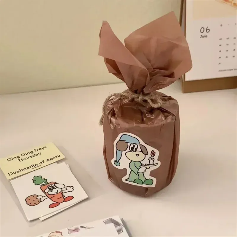 Round custom sticker label on a brown gift bag with tied ribbon.