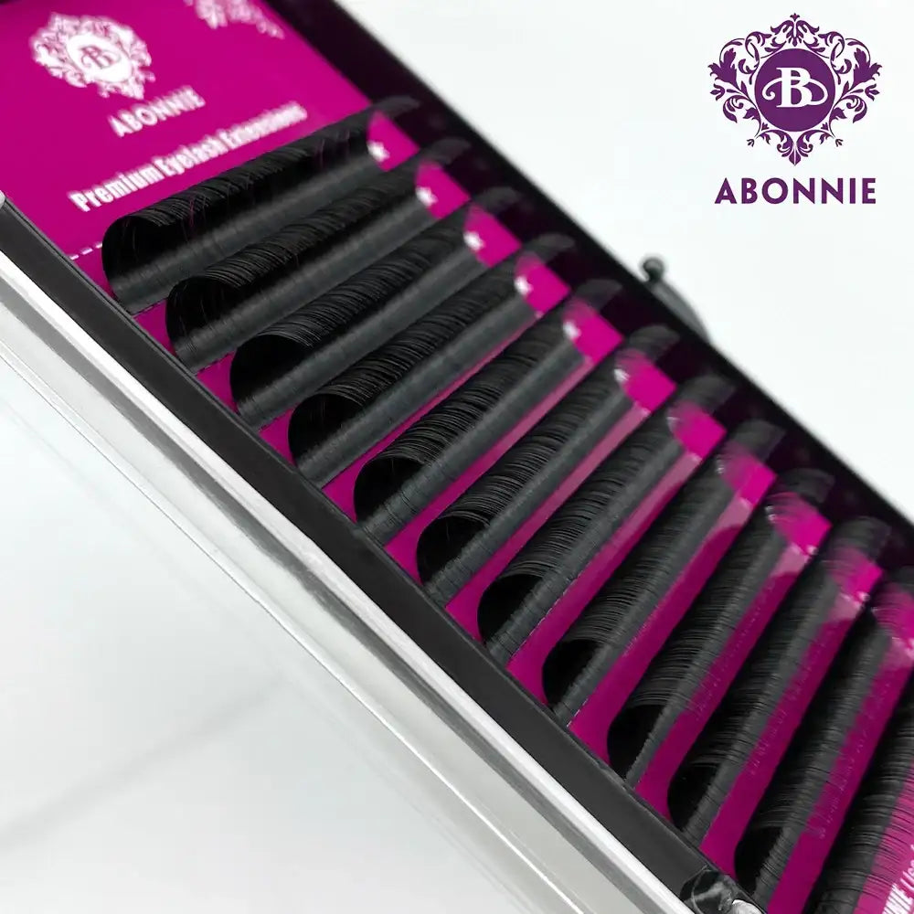 Abonnie premium black eyelash extension strips arranged in rows inside a magenta and black branded tray.