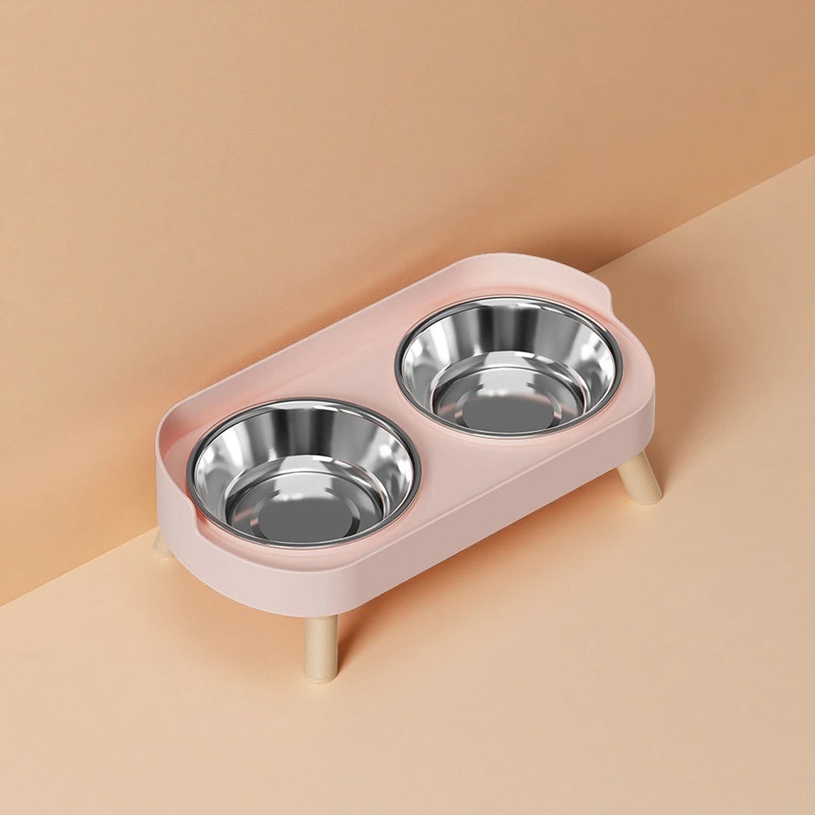 Pink elevated dual pet feeder with stainless steel bowls for anti-slip, neck-protecting cat and dog dining.