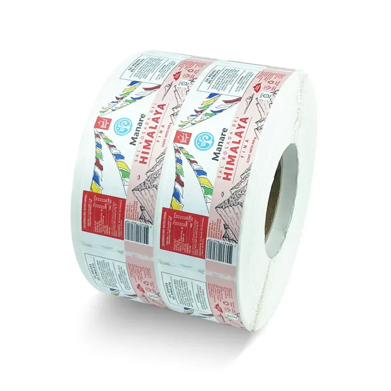 Roll of colorful adhesive barcode labels on clear PVC vinyl, printed with multi-color designs.