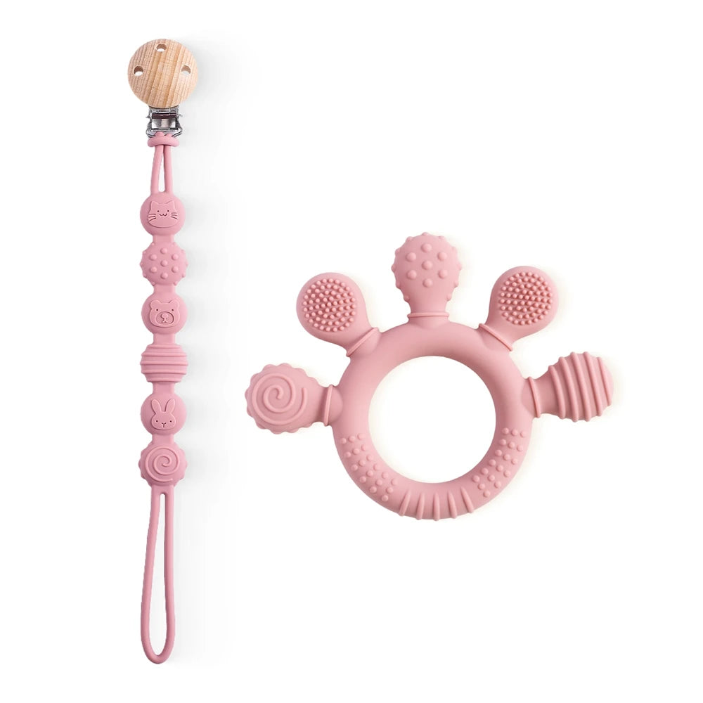 Pink silicone baby teething ring and pacifier clip set for soothing teething pain.