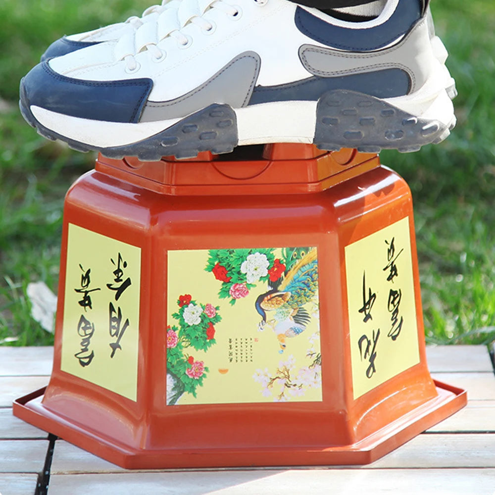 Orange resin planter with floral illustration on the front panel and four feet