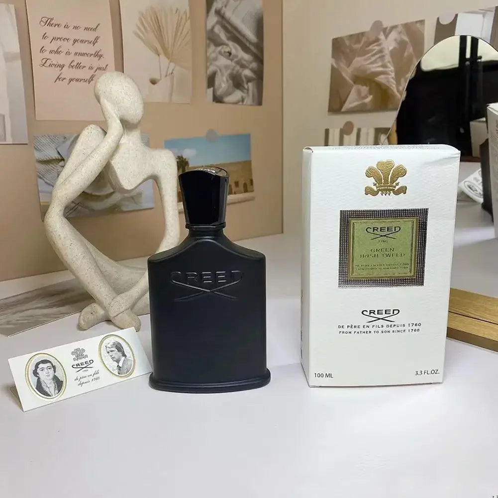 Green Irish Tweed 100ml matte black glass fragrance bottle and white box packaging on a white surface.