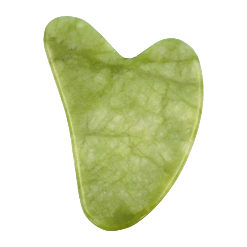 Heart-shaped light green jade gua sha stone massage tool with a smooth, marbled texture on a white background.